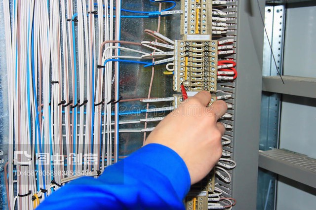 電工的手對電器柜的端子進(jìn)行接線。The electrician`s hand carries out wiring to the terminals of the electrical cabinet.